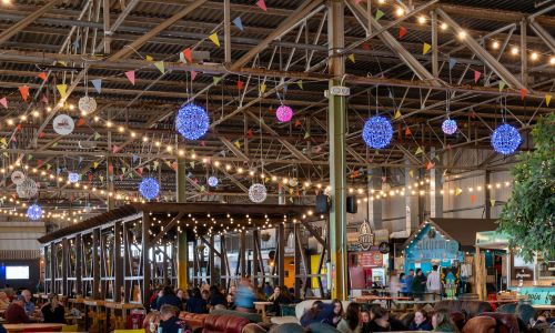 Inside image of the marina market colour lights hanging from the roof