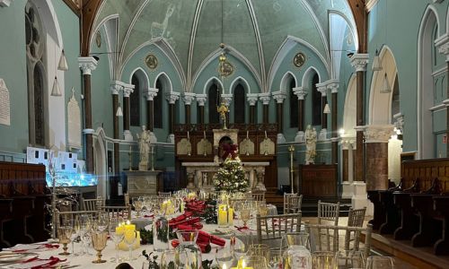 interior of Goldie Chapel in Nano Nagle with round tables set for dinner with white table cloths, candles and flowers