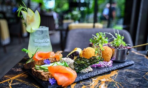 Platter of salmon and brown bread on a black slate with a rebel city drink  lovely vibrant colours