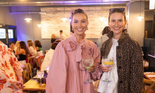 Two girls drinking from Gin & tonic glasses smiling