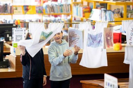 Roam Exhibition at Mayfield Library - two primary school girls with printed t-shirts hanging from a line