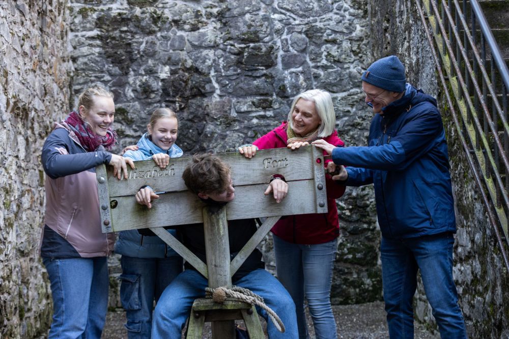 Family Trying Out The Stocks At Elizabeth Fort