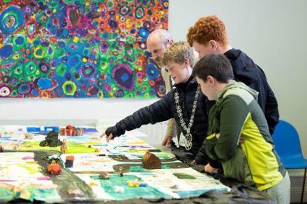 Three 5th class boys from St. Mary's on the Hill NS look at artwork with Councillor Oliver Moran at the Roam exhibition in Knocknaheeny Youth Project