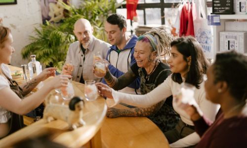 A group of people holding their drinks glasses at the bar