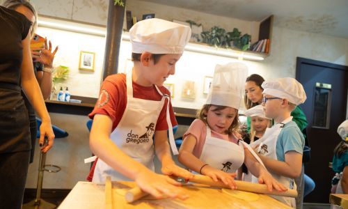A group of kids making pasta