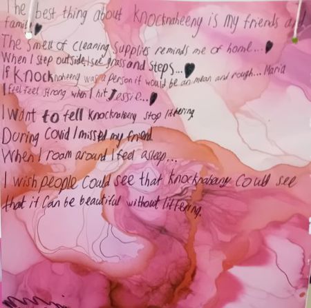 Child's marbled painting with handwritten message: "The best thing about Knocknaheeny is my friends and family. The smell of cleaning supplies reminds me of home... When I step outside I see grass and steps... If Knocknaheeny was a person it would be an mean and rough... Maria. I feel reel strong when I hit Jessie. I want to tell Knocknaheeny stop littering. During Covid I missed my friend. When I roam around I feel asleep... I wish people could see that knocknaheeny could see that it can be beautiful without littering."